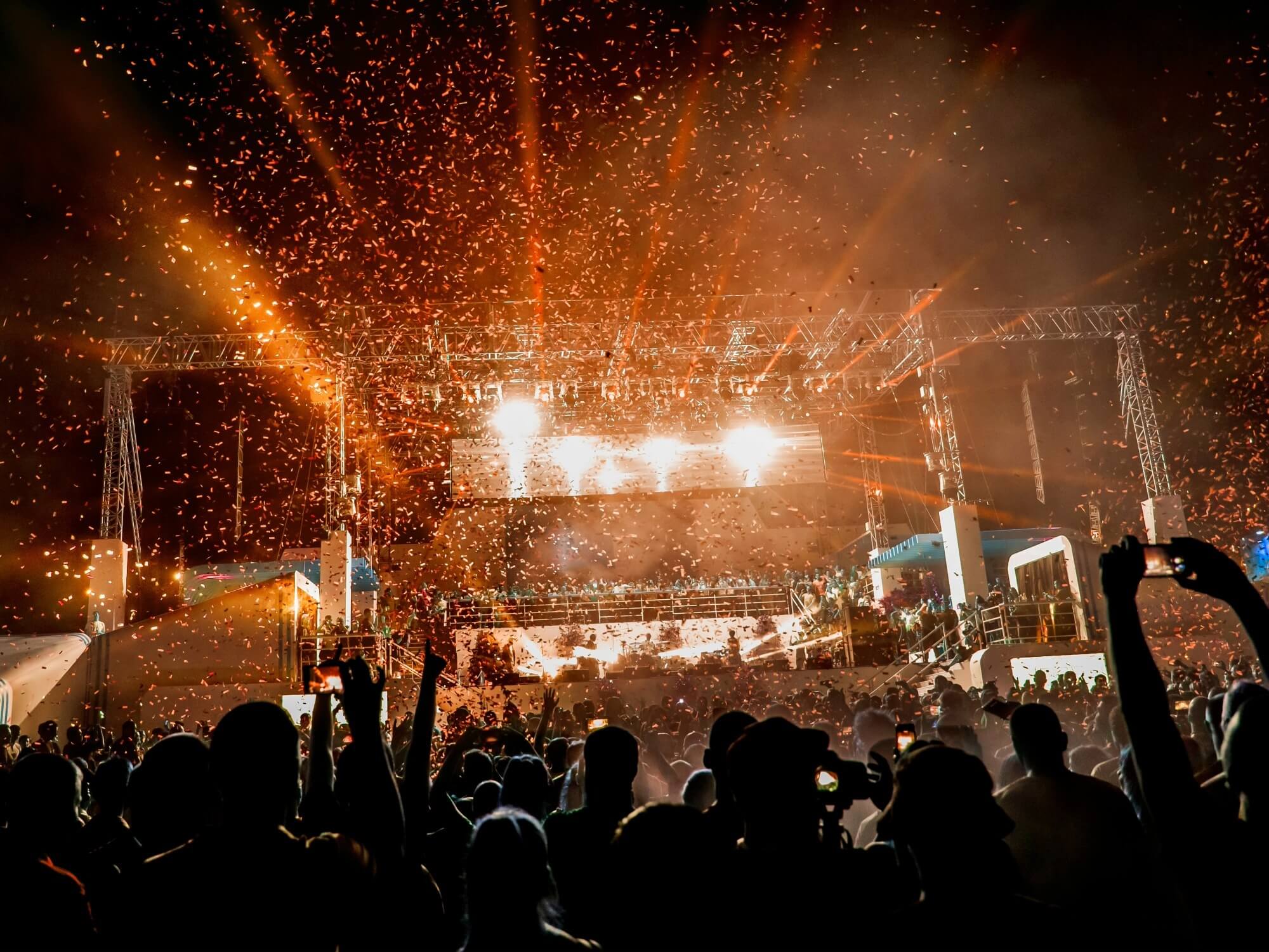 大きな会場で盛り上がっているライブの写真